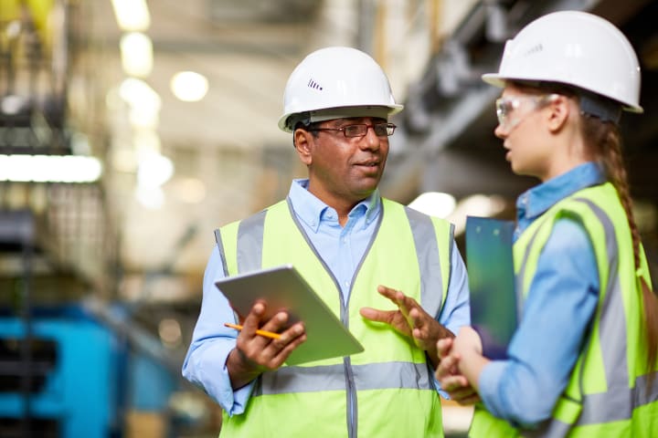 Two engineers discussing work using tablet Two engineers discussing work using tablet