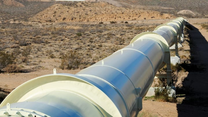 Pipeline in the desert with mountains on the horizan Pipeline in the desert with mountains on the horizan