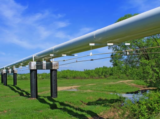 Aboveground steel pipeline in a green surrounding