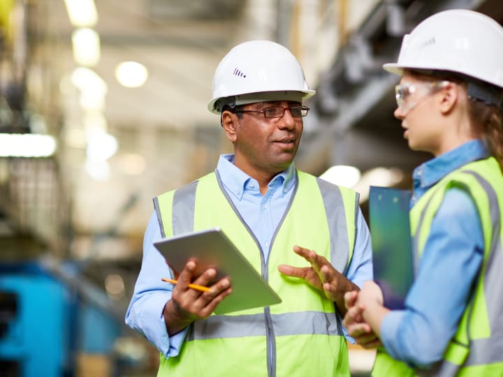 Two engineers discussing work using tablet Two engineers discussing work using tablet
