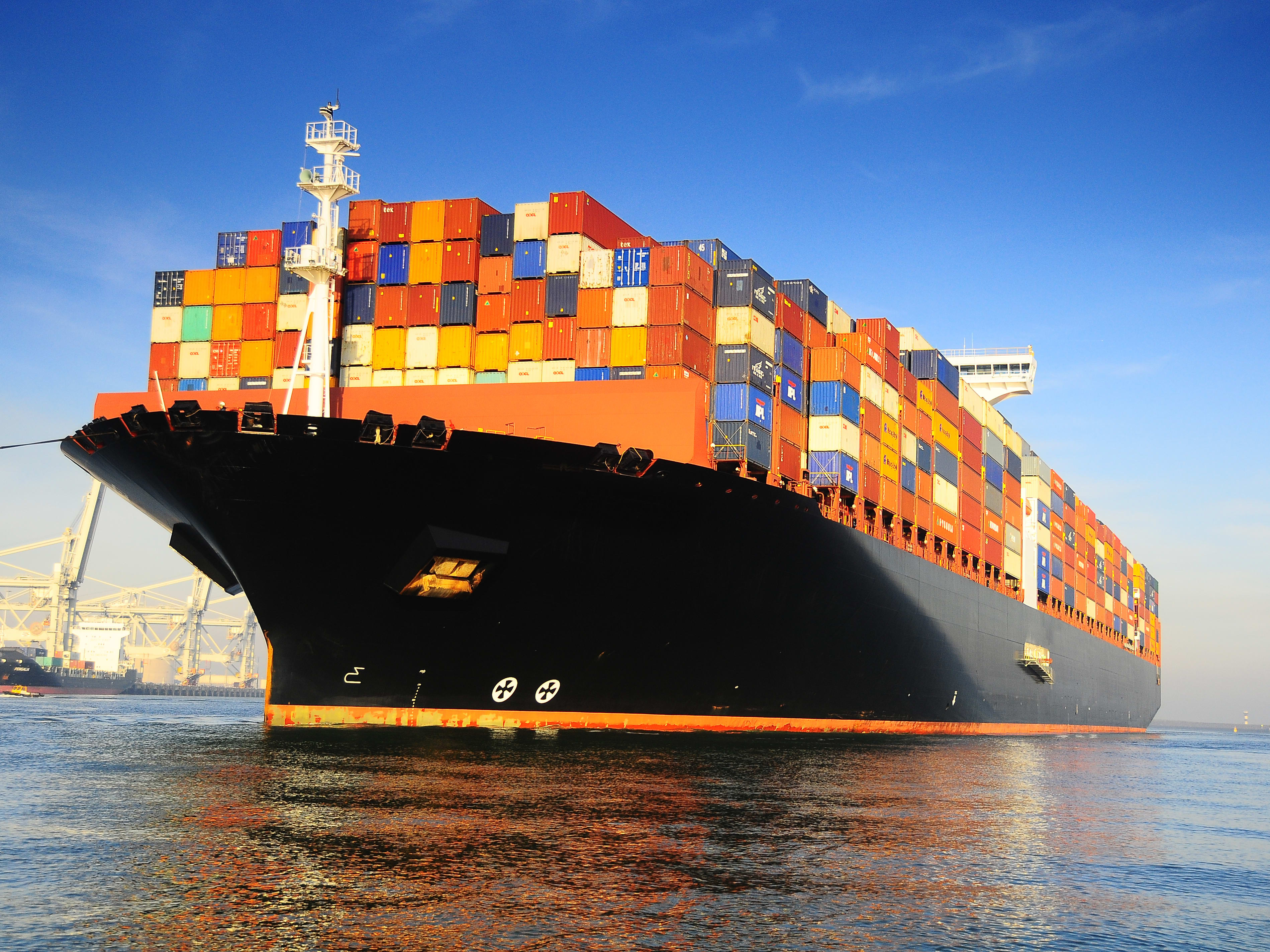 Container ships in the marine industry Orange and black loaded container ship in harbour