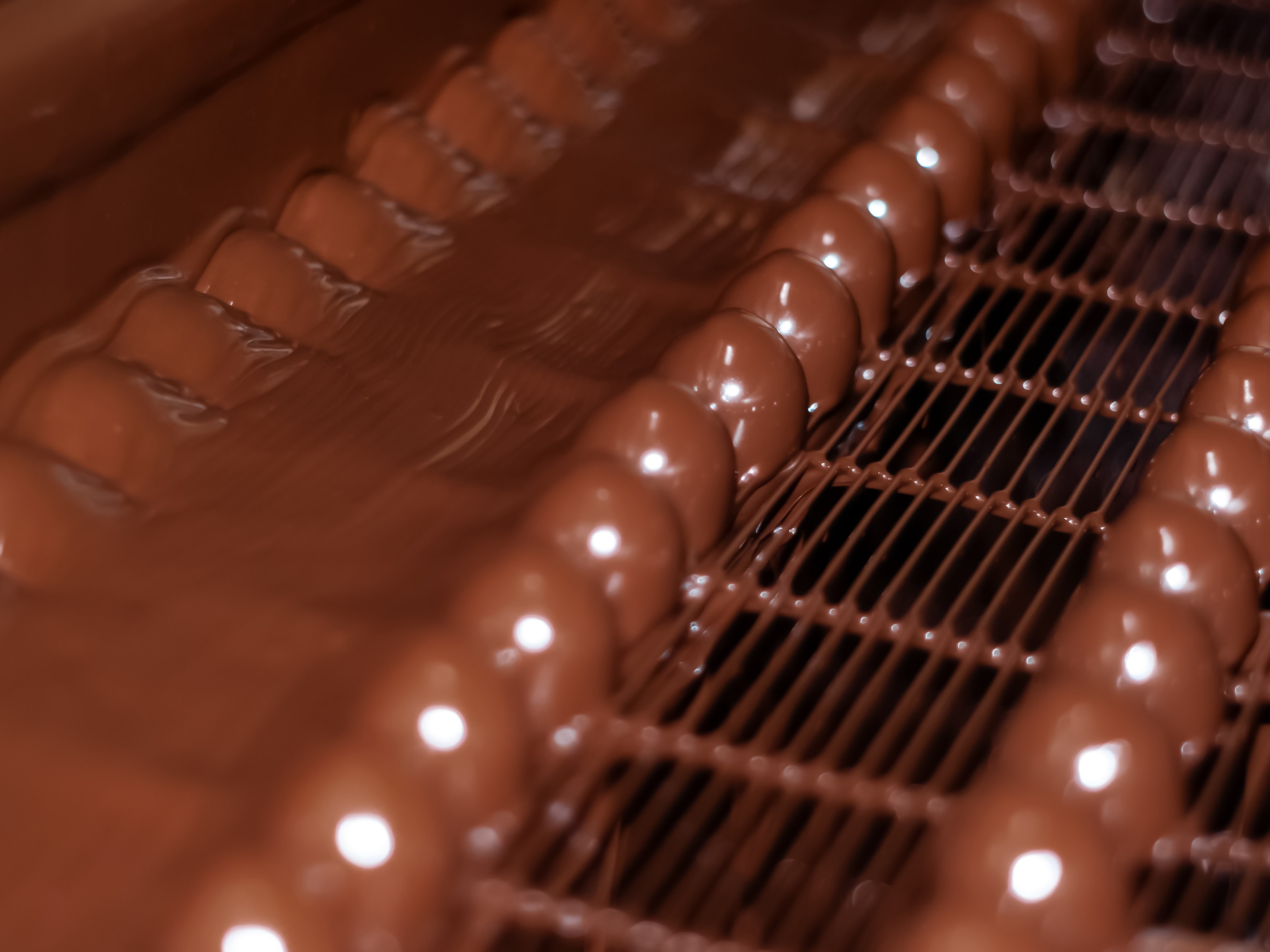Производство шоколада в пищевой промышленности Chocolate candies on the convey or of a confectionery factory close up