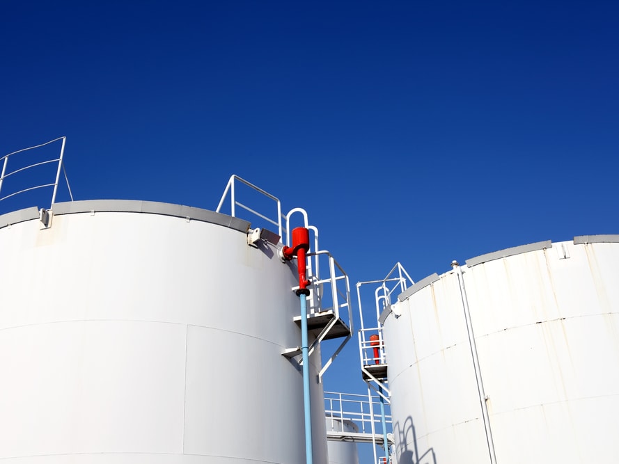 Level measurement with remote data communication White industrial storage tanks with blue clear sky in the background