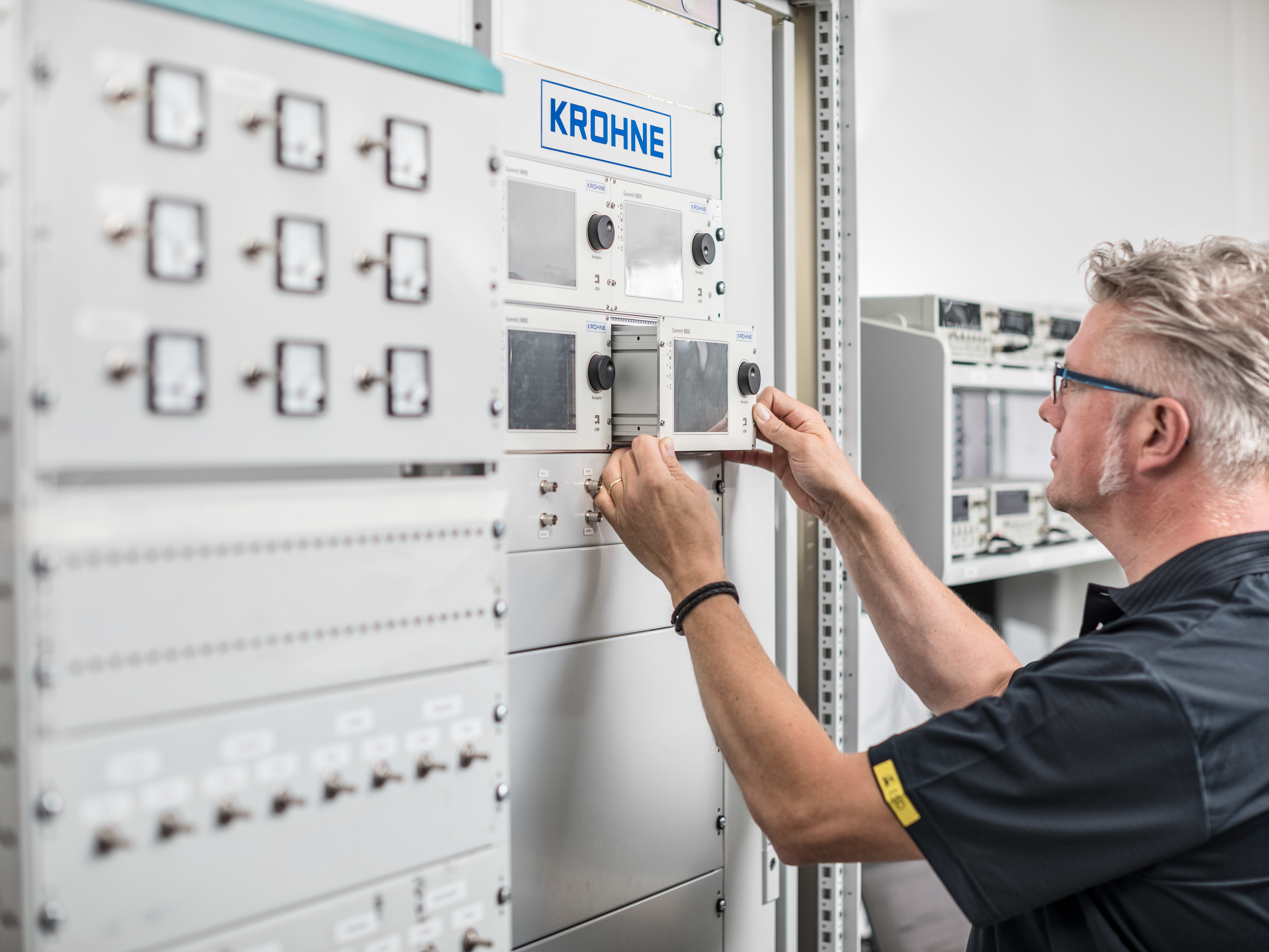 Technician inserts an SUMMIT 8800 flow computer inside a cabinet Technician inserts an SUMMIT 8800 flow computer inside a cabinet