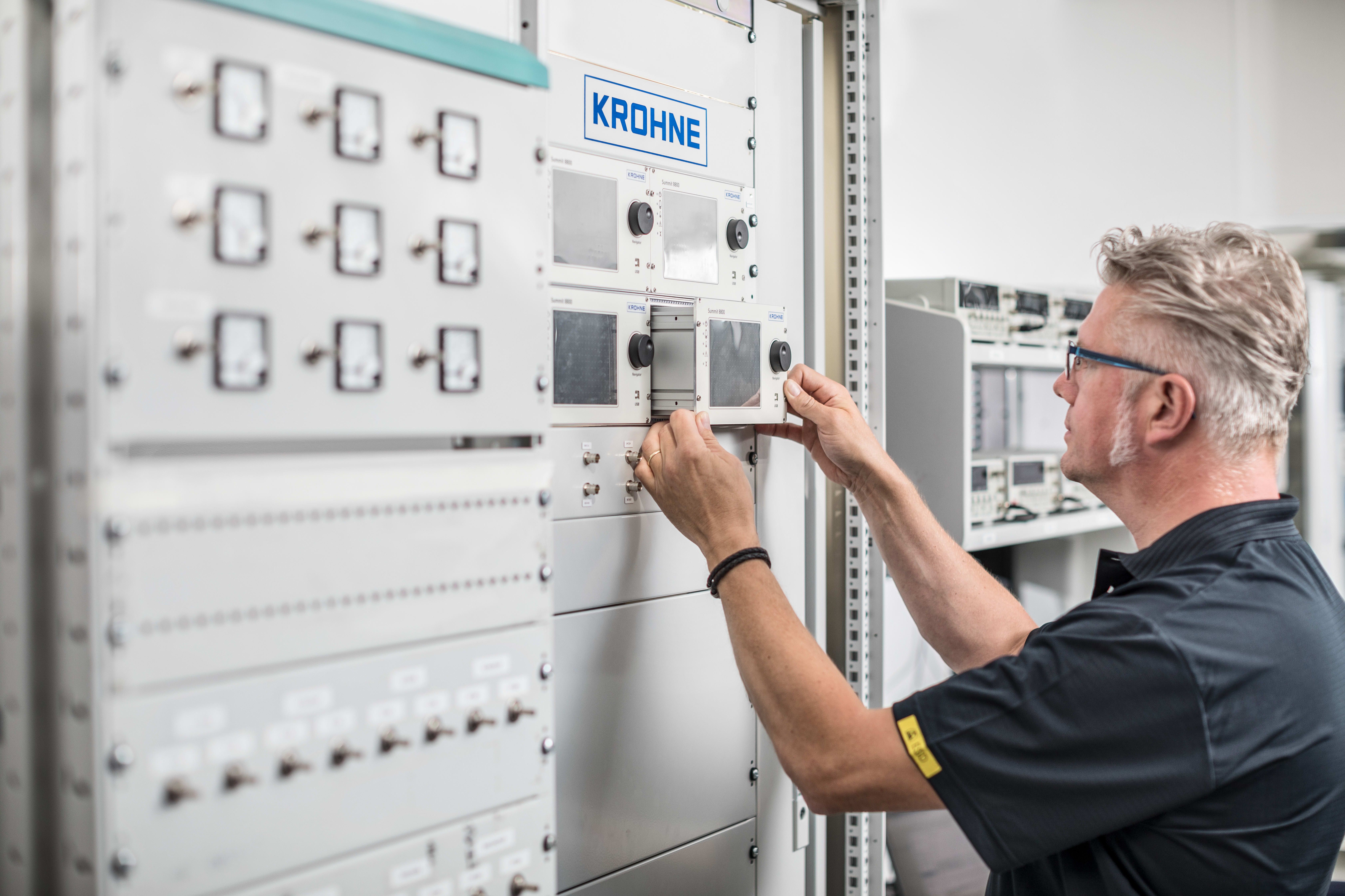 Technician inserts an SUMMIT 8800 flow computer inside a cabinet Technician inserts an SUMMIT 8800 flow computer inside a cabinet